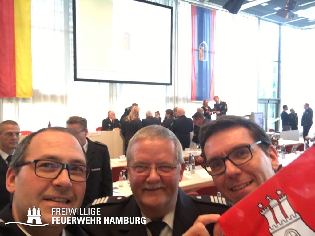 Gruppenselfie: Harald Burghart, Andreas Neven und Kai Winter (von links) vertreten die Freiwillige Feuerwehr Hamburg mit hochgehaltener Flagge. 